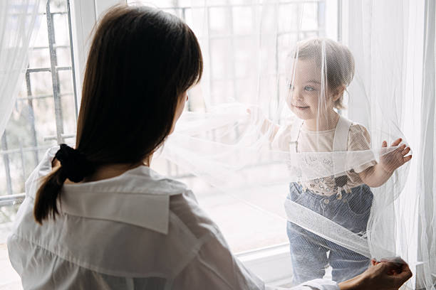 istock Bonding Through Simple Play Activities. Parent-child interaction, quality time, joyful moments, playing with curtains, strengthening relationships. 2233630452