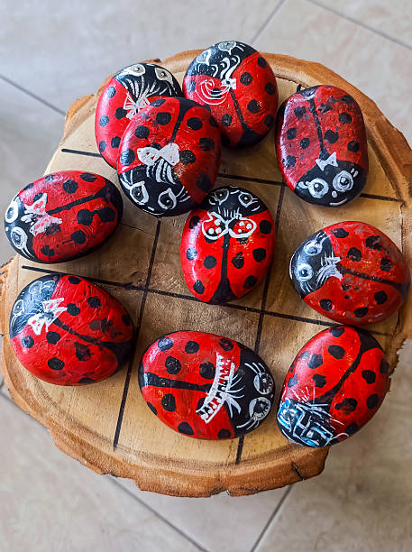 istock The painted stones are decorated with multicolored ladybirds in a circular pattern on a wooden stump. 2233632667