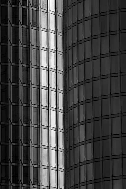 istock Modern glass skyscraper facade with abstract geometric reflections and curved architecture in black and white urban city design 2233639385