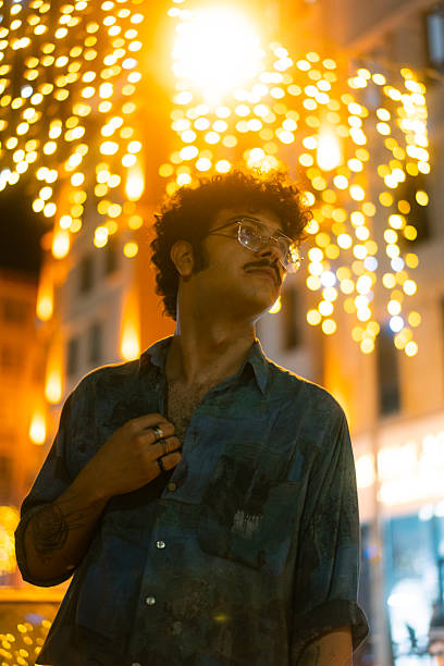 A portrait of a handsome man lit by neon lights at night in the city.