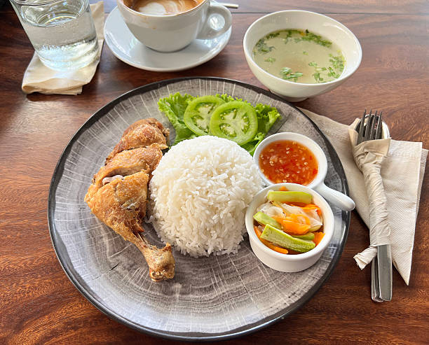 Crispy fried chicken drumstick served with rice, pickled vegetables, and sweet spicy dipping sauce.