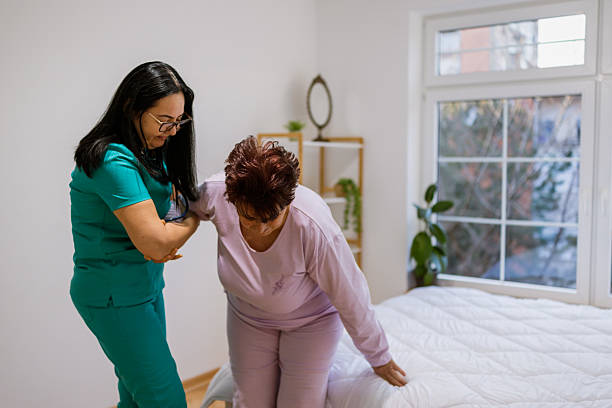 istock Elderly woman receiving help to sit from nurse 2233643312