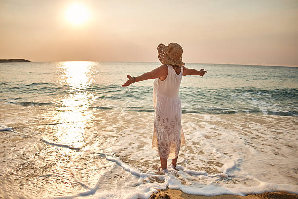 istock Senior woman enjoying walking along the beach 2233643831