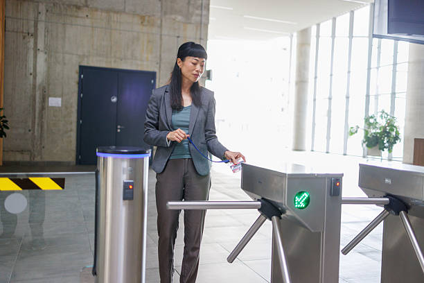 istock Businesswoman using badge to enter office building through turnstile gate 2233644343
