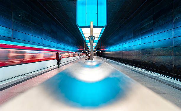 Germany, Hamburg, subway station Hafencity, June 09, 2023 - Rear view of a person with a backpack in front of an approaching subway train