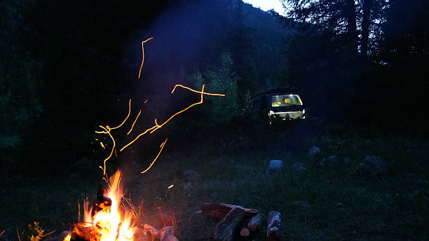 istock Campfire burning brightly in wilderness with off road vehicle in background 2233652499