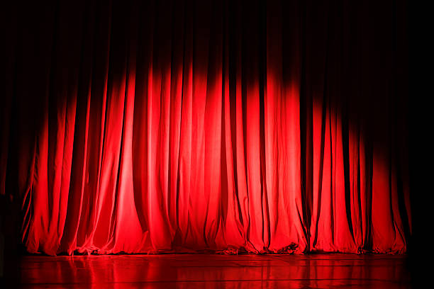 istock Closed red curtains on theater stage with spotlight 2233653821