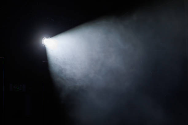 istock Light beam illuminates dark space with smoke in the air, creating an atmospheric effect at night 2233654152