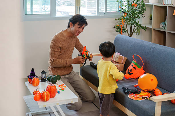 istock Halloween Family Fun: Father and Son Preparing Festive Decorations 2233654249