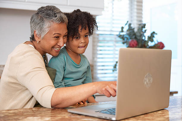 istock Mom or Grandma Sitting with son at Computer in Kitchen 2233654274