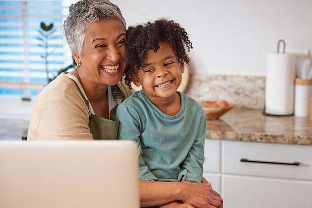 istock Mom or Grandma Sitting with son at Computer in Kitchen 2233654381