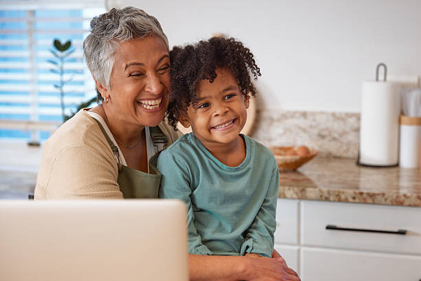 istock Mom or Grandma Sitting with son at Computer in Kitchen 2233654382