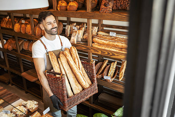 istock Handsome man working in bakery carrying basket full of breads 2233654554
