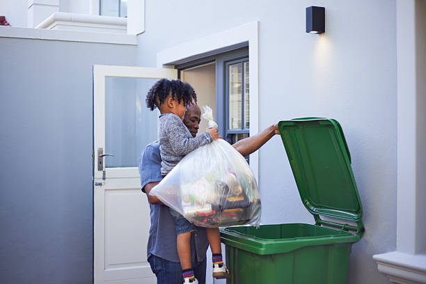 istock Young Boy Carried by Grandfather or Dad While Taking Out Recycling 2233654621