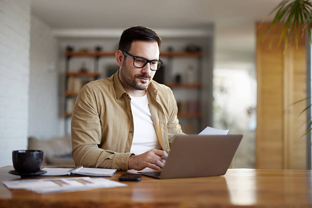 istock Businessman reading an e-mail on laptop at home. 2233657067
