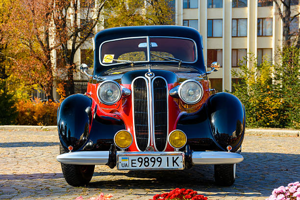 uzhhorod, ukraine - 31 oct, 2021: front view of a red bmw 321 with black hood. classic oldtimer from 40s. vintage vehicle exhibition on narodna square on a sunny day in autumn