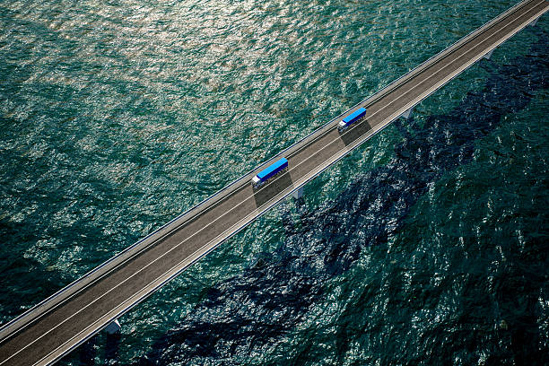 istock Two blue freight trucks on bridge over the ocean 2233664189
