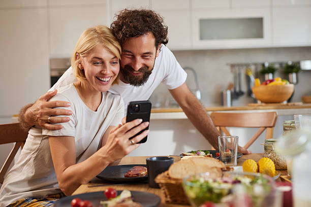 istock Couple sharing a joyful moment while looking at their phone during a cozy home 2233664469