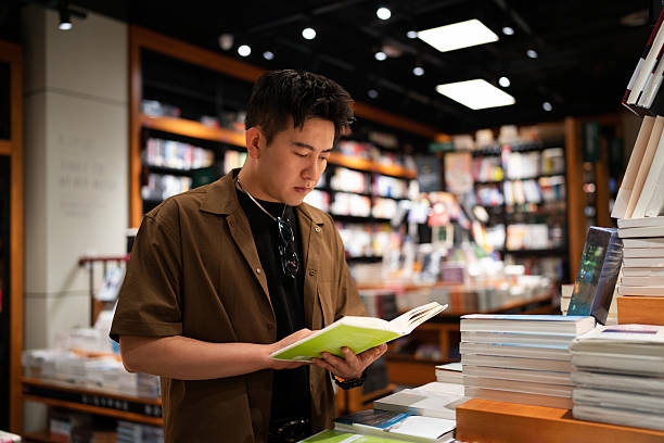 Asian handsome man buying books in bookstore