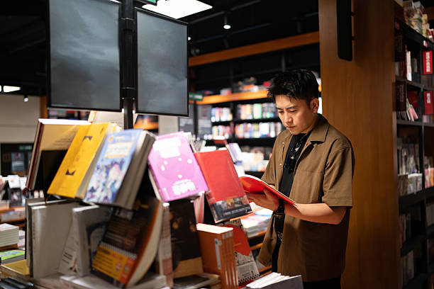 Asian handsome man buying books in bookstore