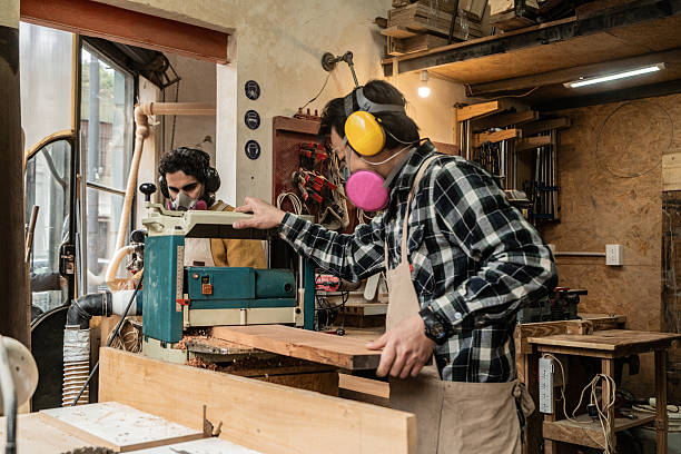 istock Carpenters shaping wood with a benchtop planer in a workshop 2233667009