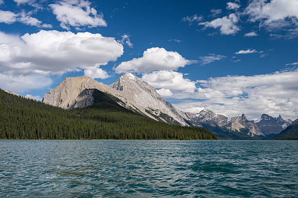 A cruise boat as it sails past Spirit Island in Jasper National Park, Alberta, Canada, concluding its panoramic tour of Maligne Lake and its surrounds.