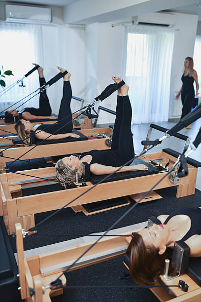istock Female Pilates Class Executing Synchronized Reformer Workout Together 2233668053