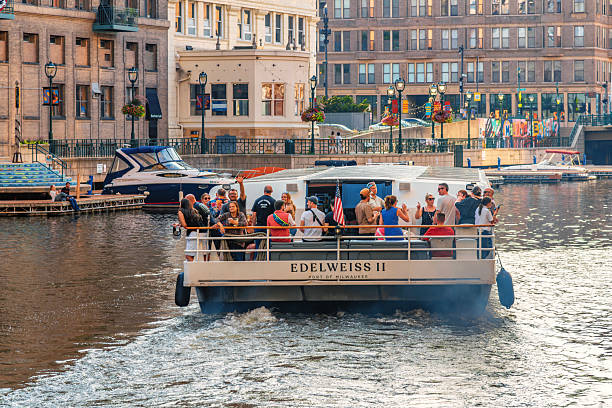 Milwaukee, United States - July 29, 2025:  A group pulls from the dock on a riverboat tour provided by a local Milwaukee boat tour company.