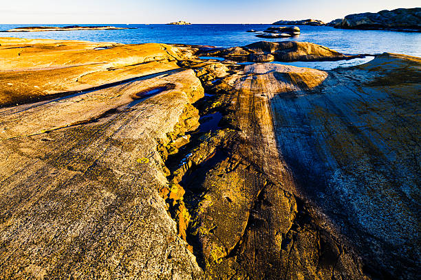 Rugged rocky shoreline leading to distant blue ocean