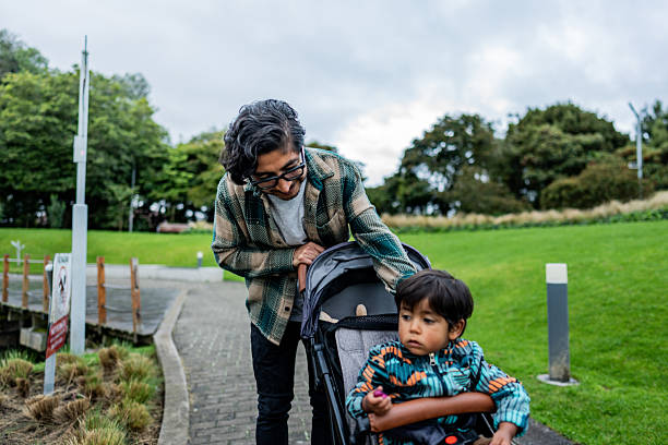 Father walking with toddler in stroller at the park