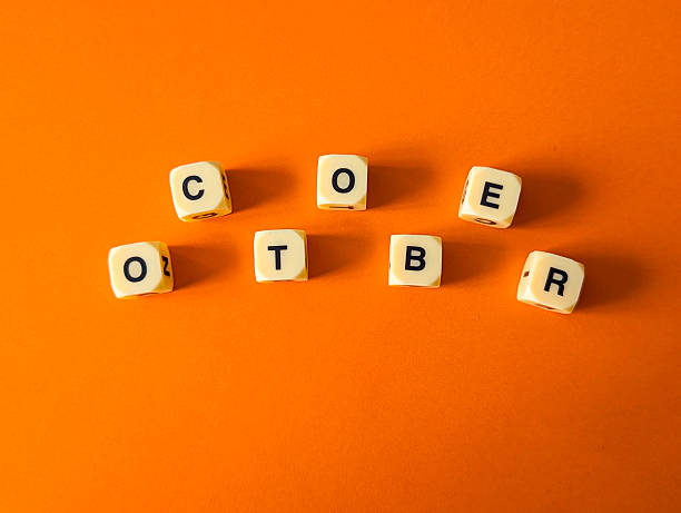 istock word “october” made of dice on bright orange background 2233672120