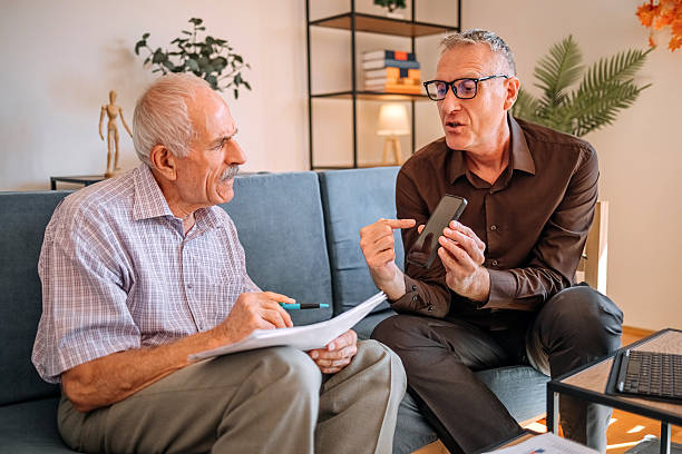 istock Businessman with finance occupation working at clients home using digital tablet so he can explain better where to invest savings 2233675008
