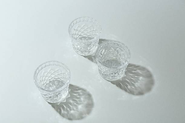 istock Beautiful crystal glasses casting shadows on light background 2233676583