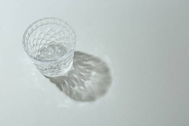 istock Beautiful crystal glass casting shadow on light background. Space for text 2233676586