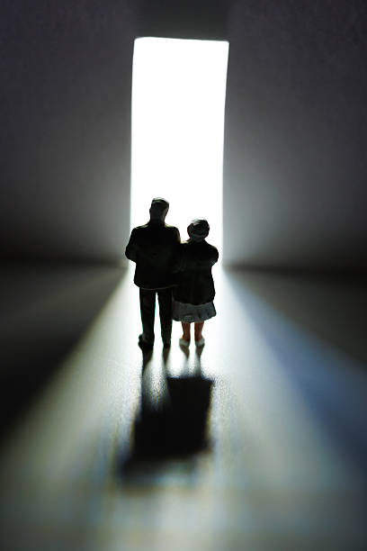 istock Elderly couple walking away towards light through open door 2233677008