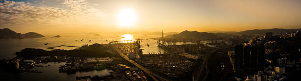 Aerial panoramic view of hong kong stonecutters bridge and container port at sunset