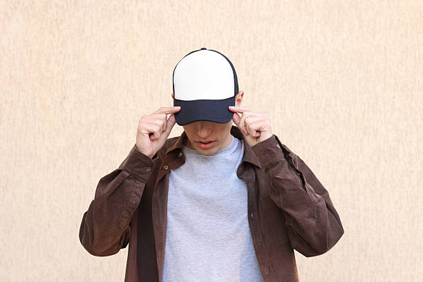 istock Man in stylish baseball cap near beige wall. Mockup for design 2233678341