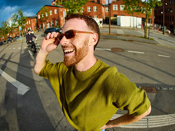 istock Young man adjusting sunglasses and smiling while commuting in the city 2233679831