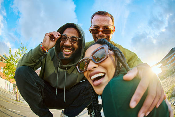 Three young adults smiling and having fun outdoors