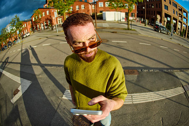 istock Young man adjusting sunglasses and smiling while commuting in the city 2233679845