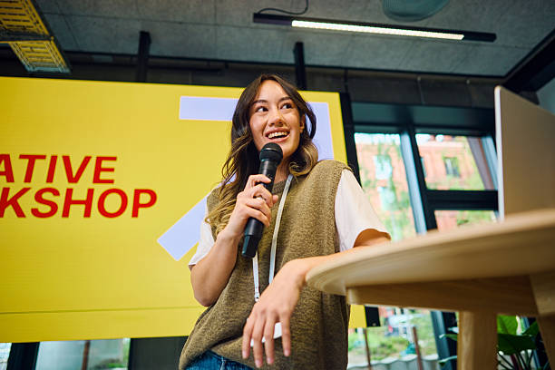 istock Young woman speaking at creative workshop with microphone 2233679861