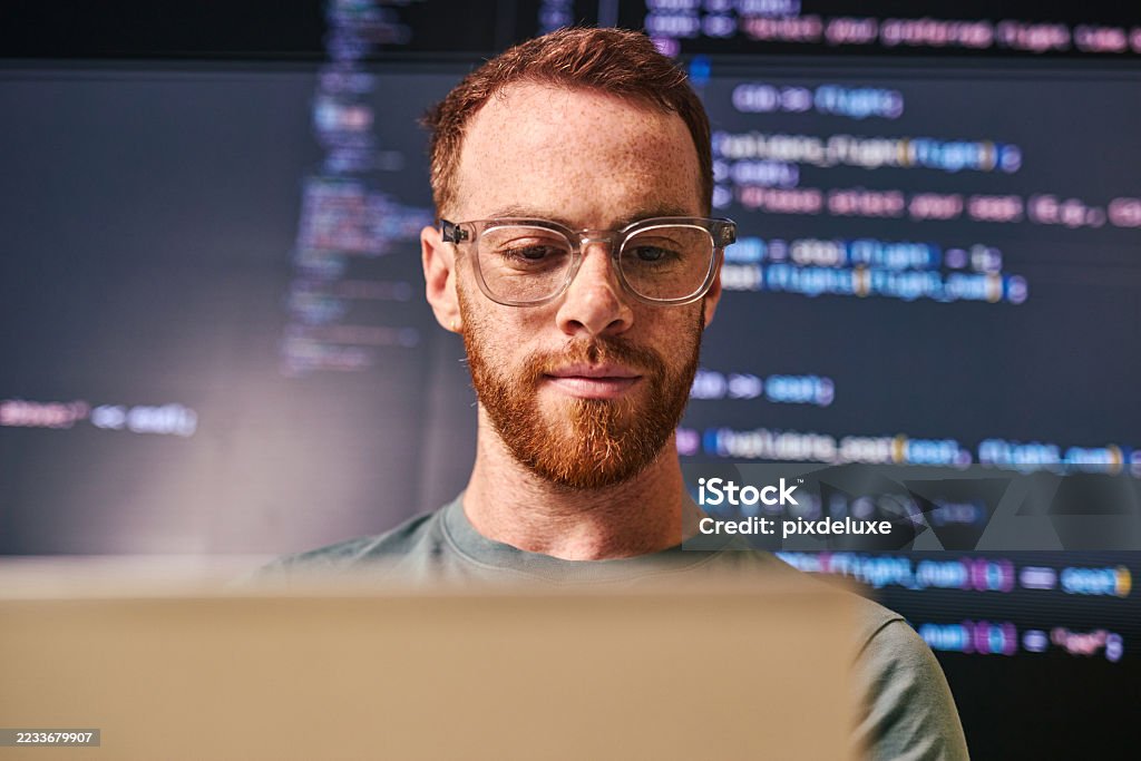 Focused software developer working on laptop with code displayed on screen in modern office Young adult male software developer concentrating on his laptop, with lines of code displayed on a large screen in the background, in a contemporary office setting Artificial Intelligence Stock Photo Focused software developer working on laptop with code displayed on screen in modern office Young adult male software developer concentrating on his laptop, with lines of code displayed on a large screen in the background, in a contemporary office setting Artificial Intelligence Stock Photo