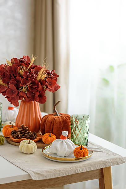 istock Thanksgiving table setting with decorative pumpkins, candles and string lights on white wooden table 2233680083