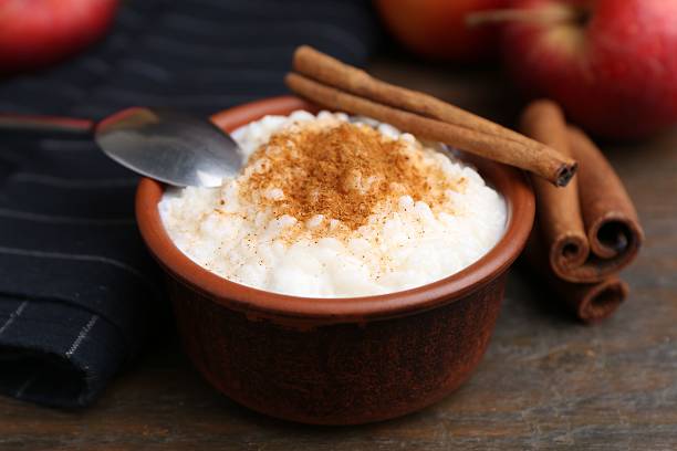 istock Delicious rice pudding with cinnamon sticks on wooden table, closeup 2233680208