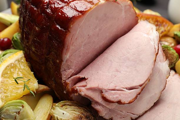 istock Tasty baked ham served with vegetables and oranges on table, closeup 2233680522