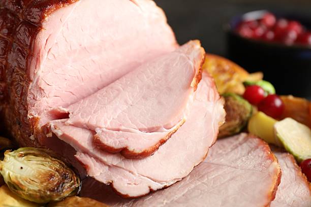 istock Tasty baked ham served with vegetables and oranges on table, closeup 2233680523