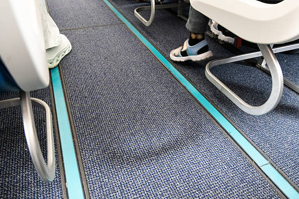 istock Close-up on airplane cabin carpeted floor with reflective and illuminated guide lines for evacuation during emergency 2233681024