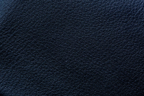 Black synthetic leather macro background texture,Natural, genuine black leather texture close up, macro. Structure of glossy leatherette, artifical skin surface with embossing pattern. Background, wallpaper, backdrop