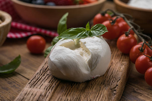 istock Burrata cheese with tomatoes on wooden board 2233686822