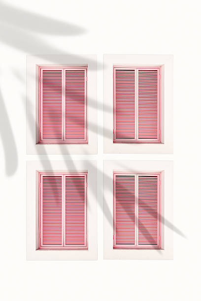 istock Minimal summer aesthetic pattern with pink shutter windows on pastel wall. Natural sunlight palm leaf shadows, modern design. Concepts of summer, vacation, tropical style architecture, home decor 2233686970